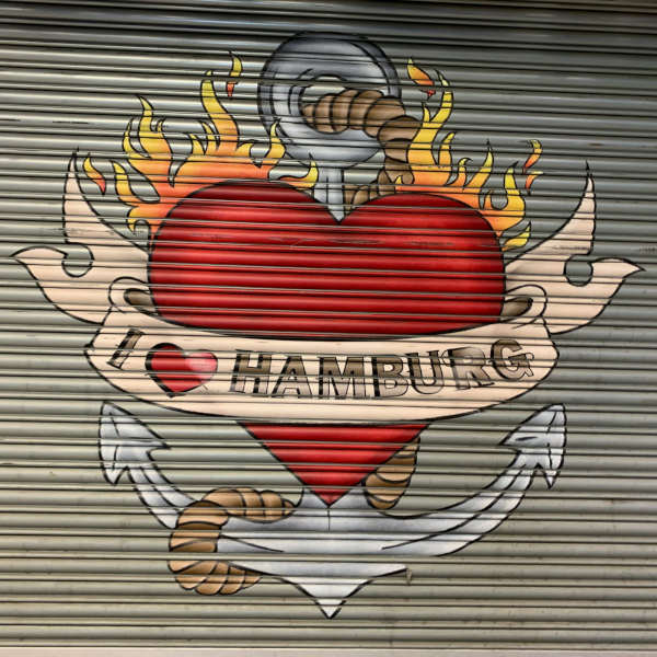 Graffiti mit brennendem Herz, Anker und „I love Hamburg“-Banner auf einem Rolltor – Symbol für emotionale Verbundenheit und Klarheit