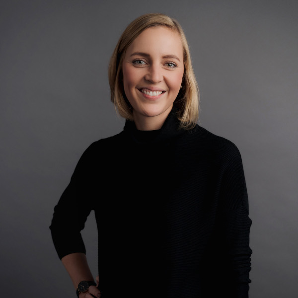 finnja thormaehlen, projektmanagerin bei friederbarth, porträtfoto mit kurzem blondem haar und schwarzem rollkragenpullover vor grauem hintergrund