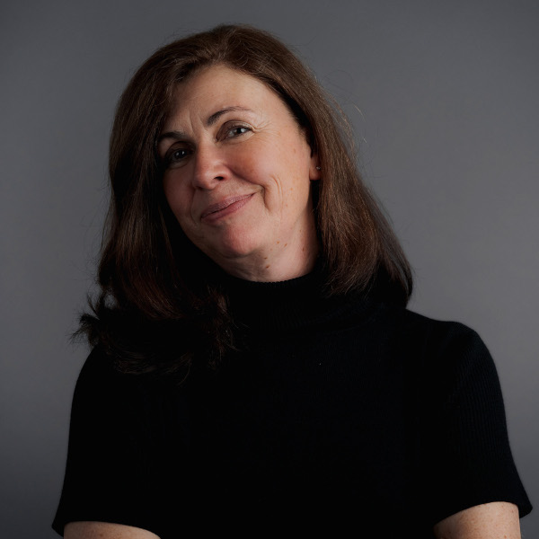 manuela barth, business administration managerin bei friederbarth, porträtfoto mit schulterlangem braunem haar und schwarzem rollkragenpullover vor grauem hintergrund
