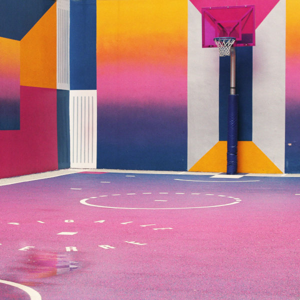 farbenfrohe Basketballhalle mit geometrischen Mustern – symbolisiert Dynamik, Bewegung und Raum für persönliche Entwicklung