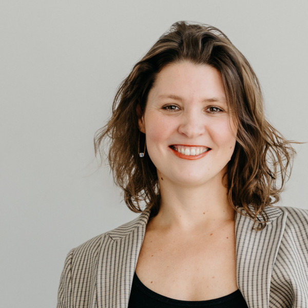 Porträt einer Frau mit schulterlangem, gewelltem Haar in gestreiftem Blazer – Symbol für professionelle Coaching-Kompetenz und persönliche Entwicklung.