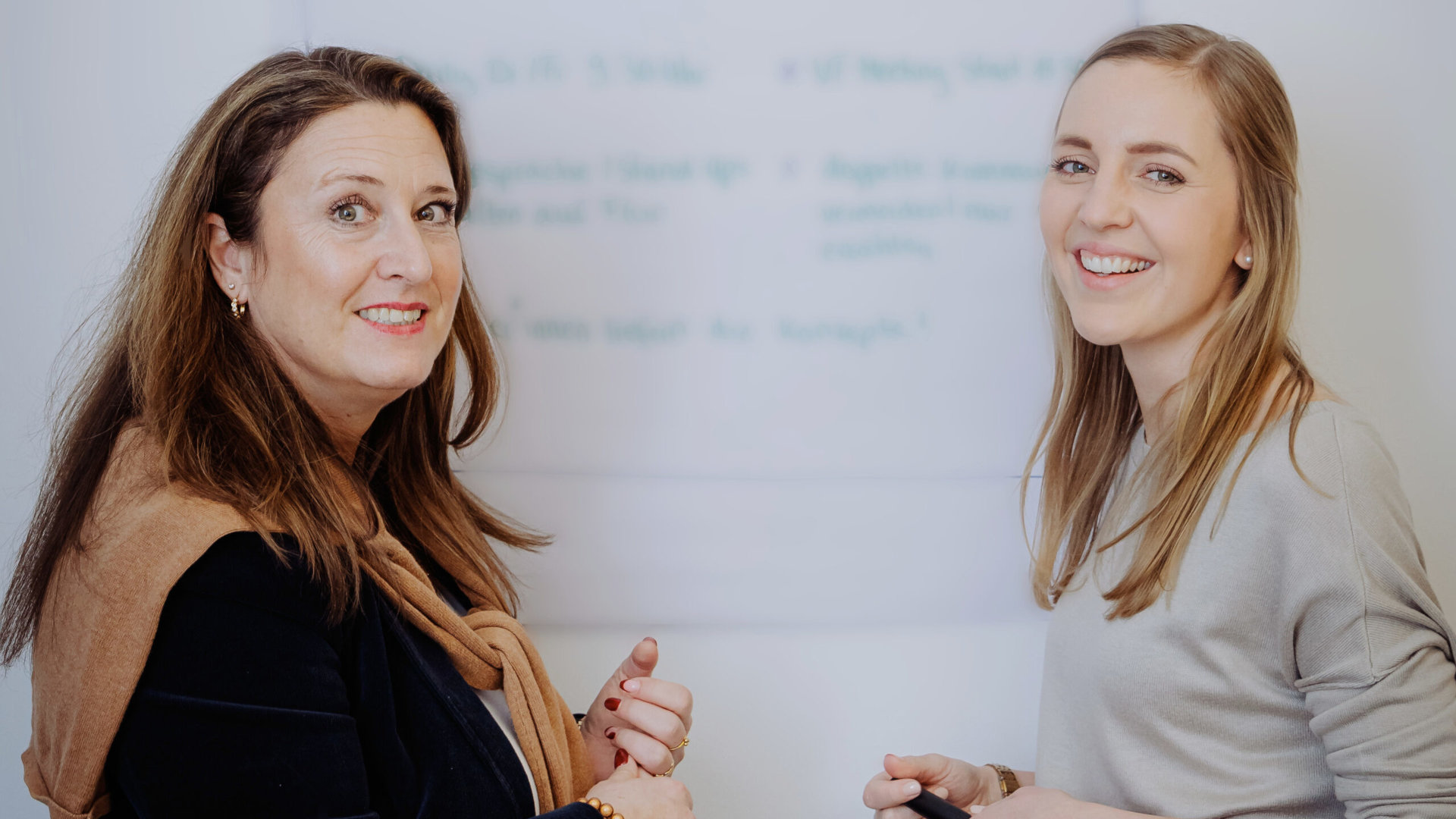 Zwei Personen im Gespräch vor einem Whiteboard, eine Person hält einen Marker – Szene aus der Case Studies Übersicht von Frieder Barth