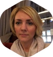 Person mit kurzem blondem Haar und hellem Schal vor einem Innenraum mit Vorhängen – symbolisch für zukunftsorientierte Weiterbildung bei Notstromtechnik-Clasen.