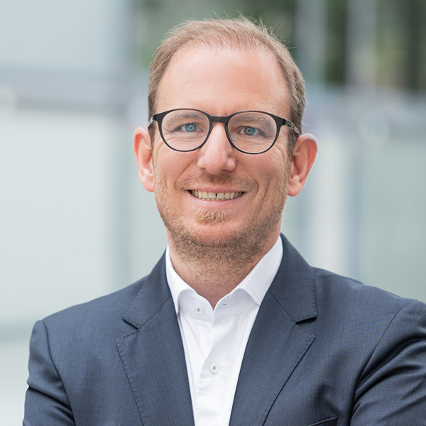 Vertriebs- und Leadership-Trainer Marco Schulz von FRIEDERBARTH steht mit verschränkten Armen und repräsentiert wertschätzende Kommunikation und Vertriebsexpertise